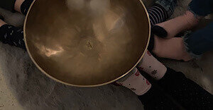 Füße berühren eine Klangschale.