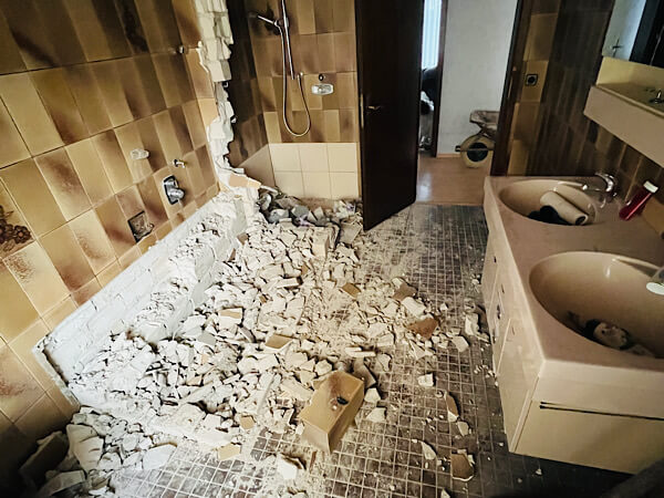 Foto zeigt ein Waschbecken und Reste von einem Steinhaufen vom Ausbau der Badewanne,