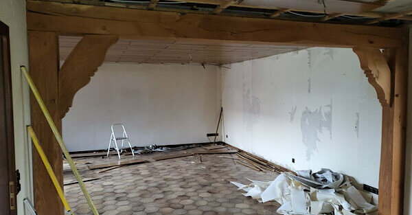 Wohnzimmer mit halboffener Decke und Tapetenresten