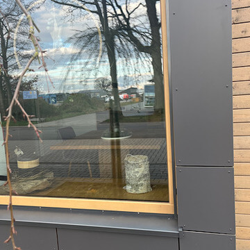 Das Bild zeigt ein Fenster, in welchem 2 Urnen auf der Fensterbank stehen